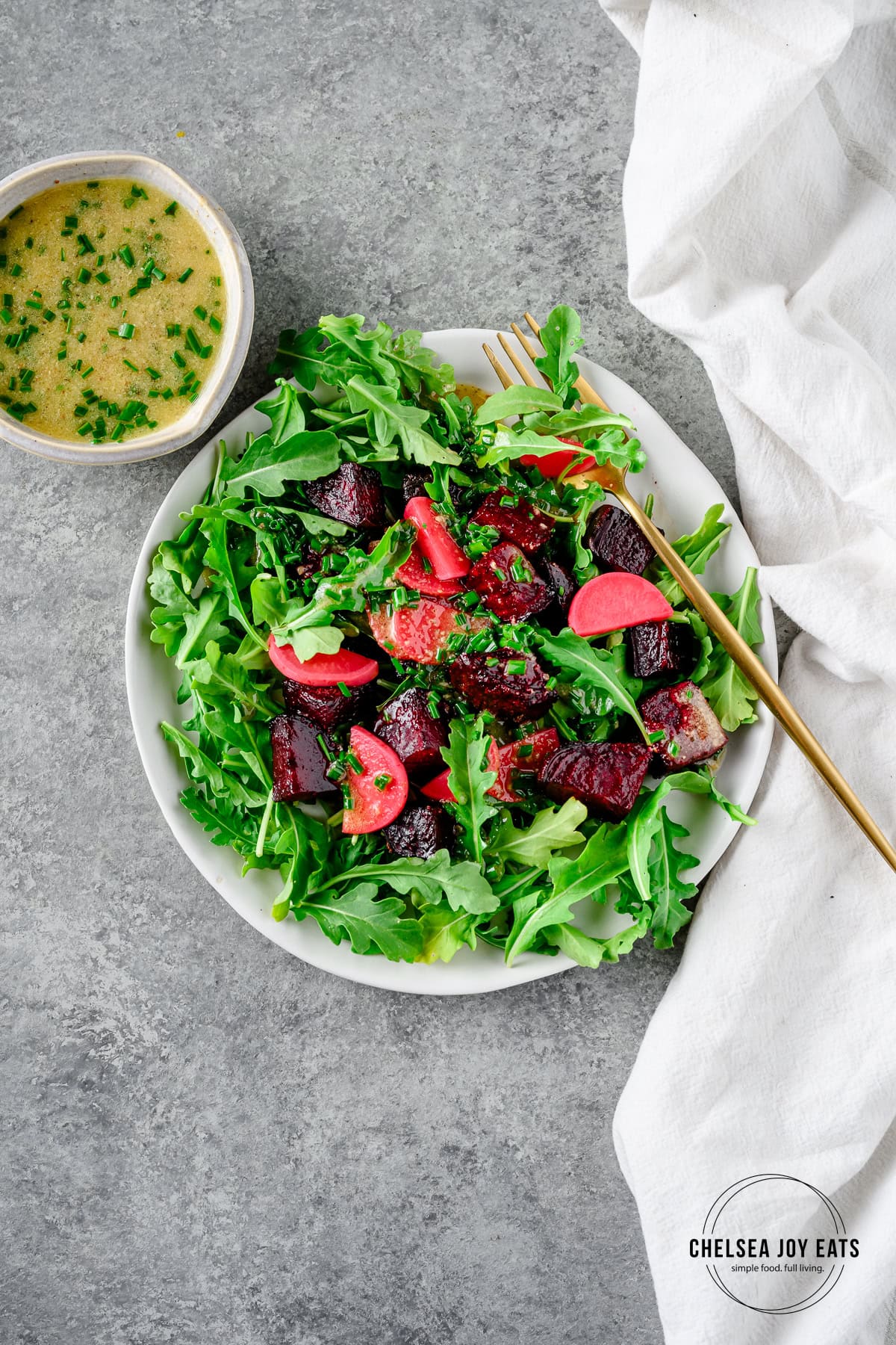 Spring salad with fresh greens, beets, and pickled radishes dressed with chive dressing.