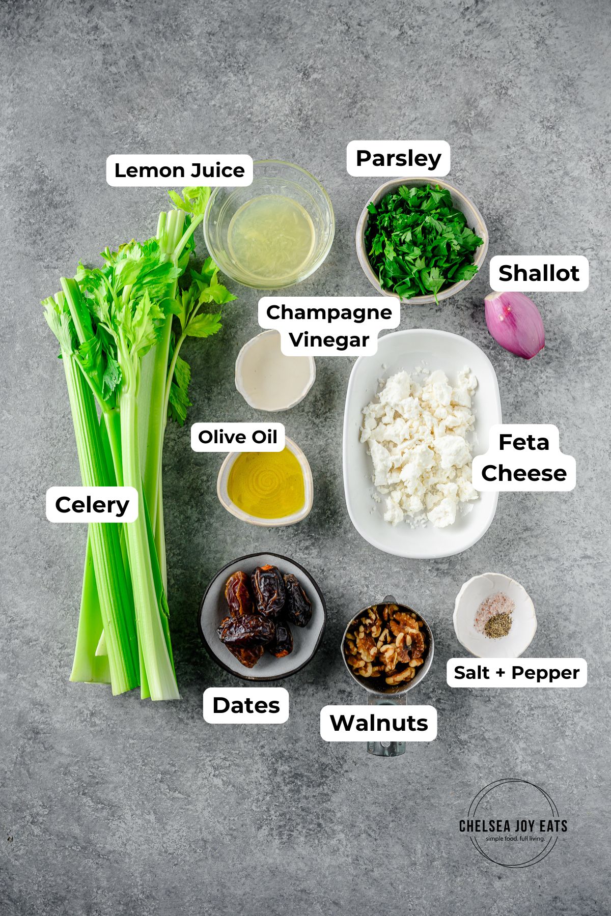 Ingredients for celery salad with dates, walnuts, and feta cheese in individual bowls with text labels for each ingredient.