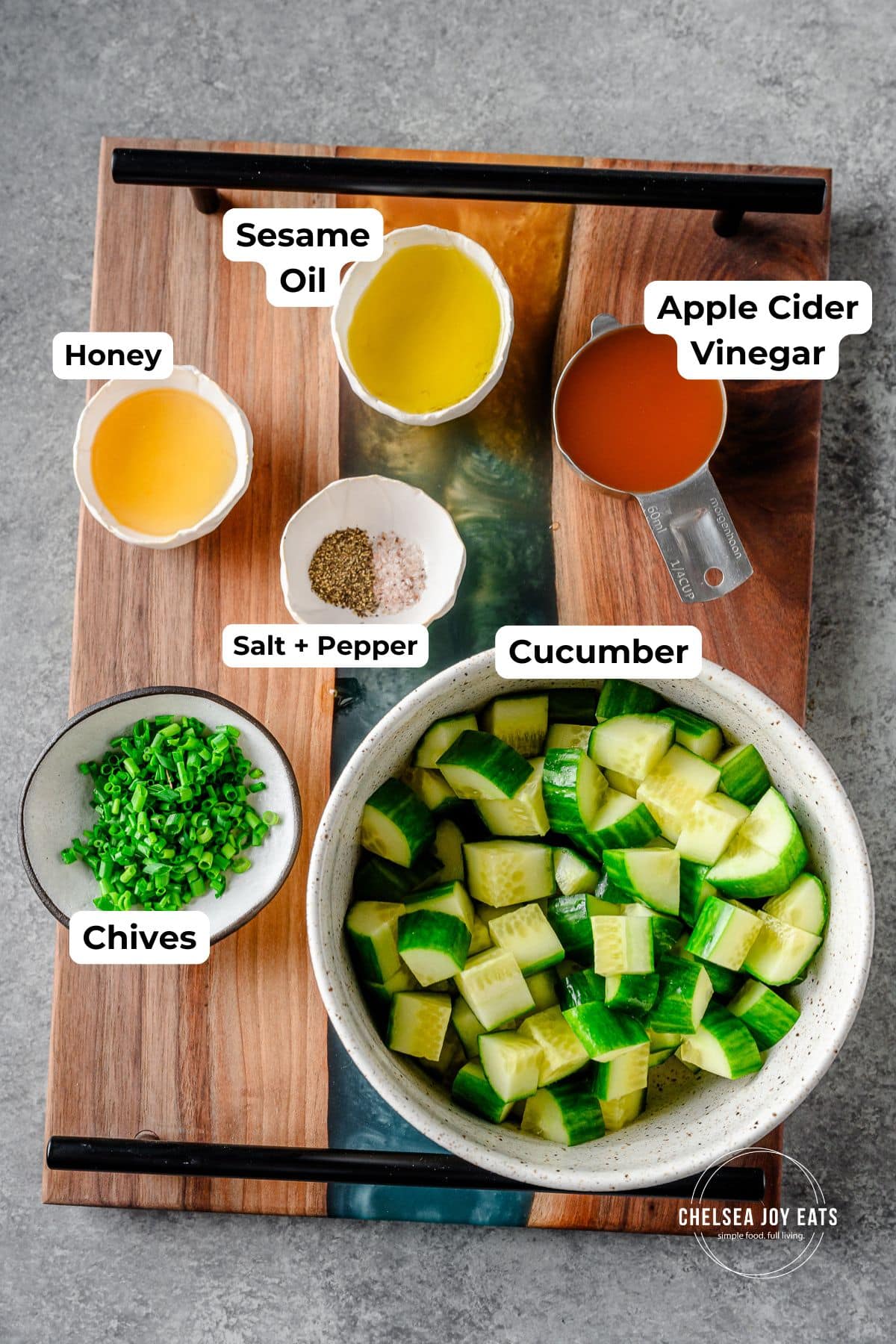 Ingredients for tangy cucumber salad in individual bowls, with text labels for each ingredient.