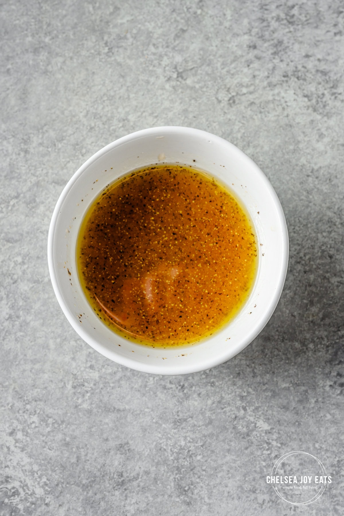 Apple cider vinaigrette in a small ceramic white bowl.