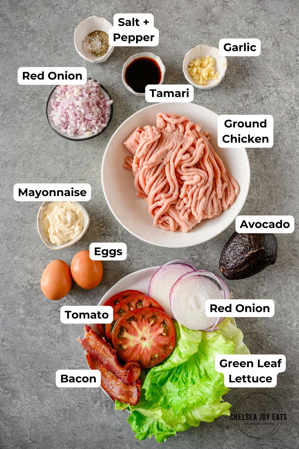 Ingredients for gluten free chicken burgers with toppings, each in an individual dish with text labels for each.