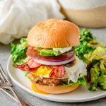 Gluten free chicken Cobb burger on a gluten free bun served with a salad.