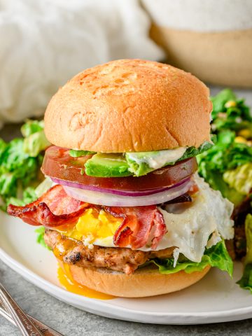 Gluten free chicken Cobb burger on a gluten free bun served with a salad.