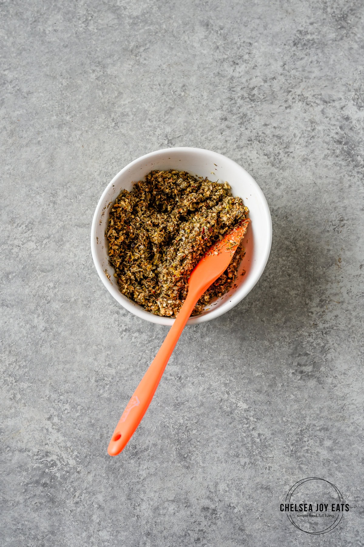 Greek spice blend mixed up in a small bowl with a spatula.