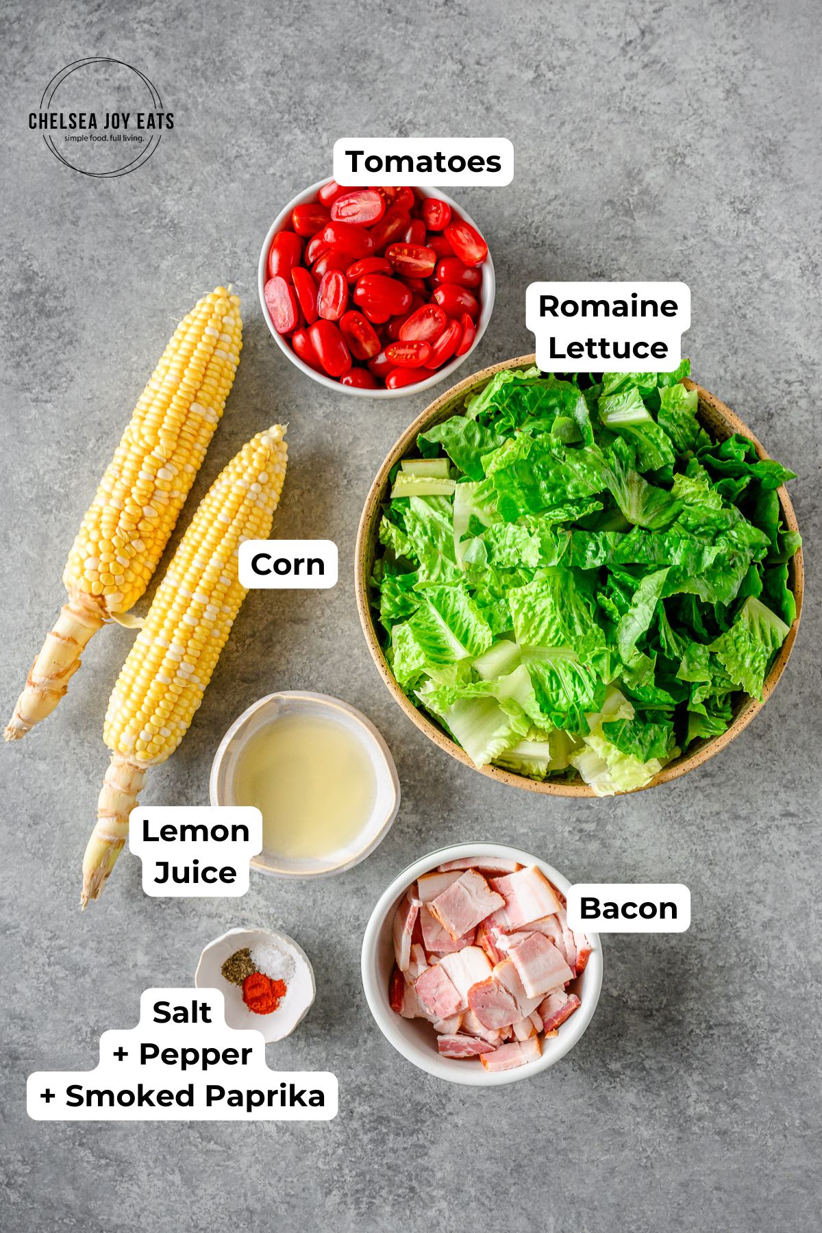 Ingredients for Corn & Tomato Salad in individual bowls with text labels for each ingredient.