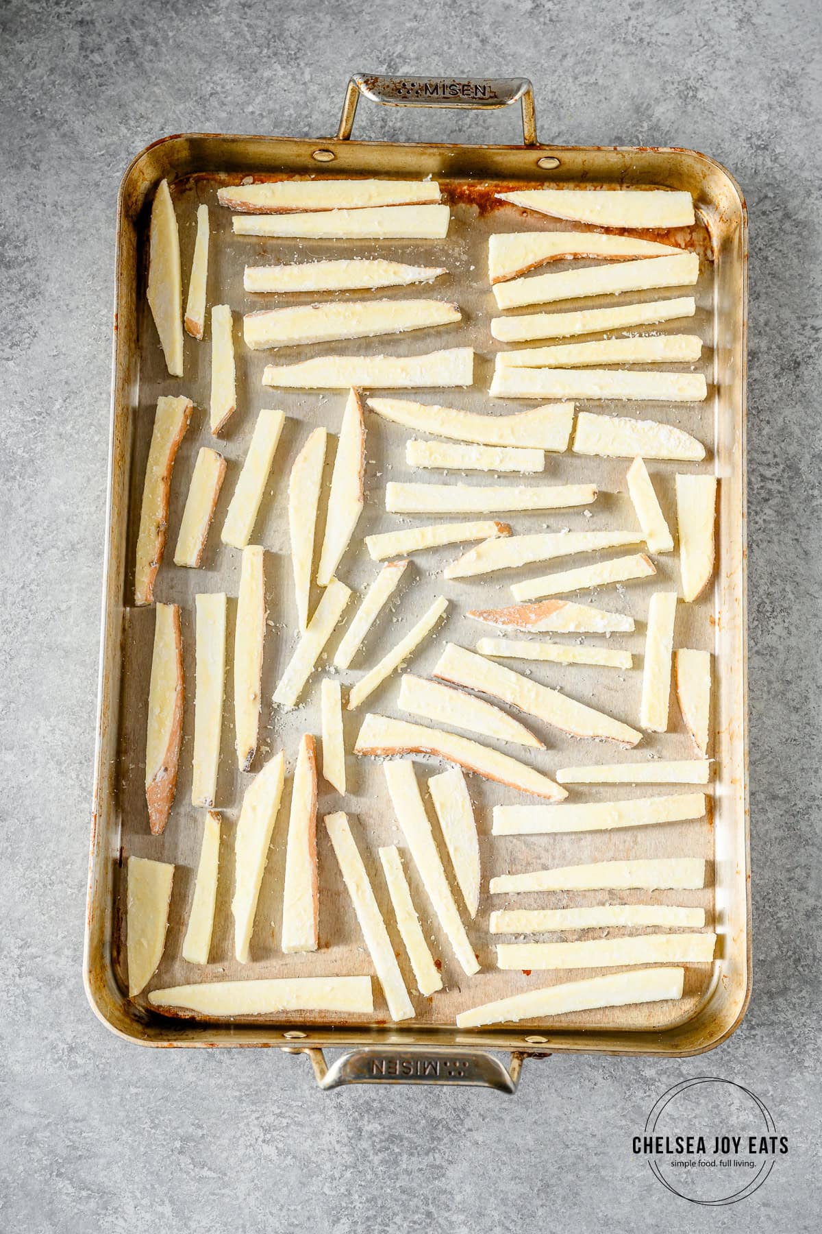 White sweet potato fries lined up on a baking sheet.
