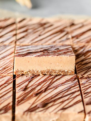 Rows of frozen no bake banana ice cream bars with one propped up to show its texture.