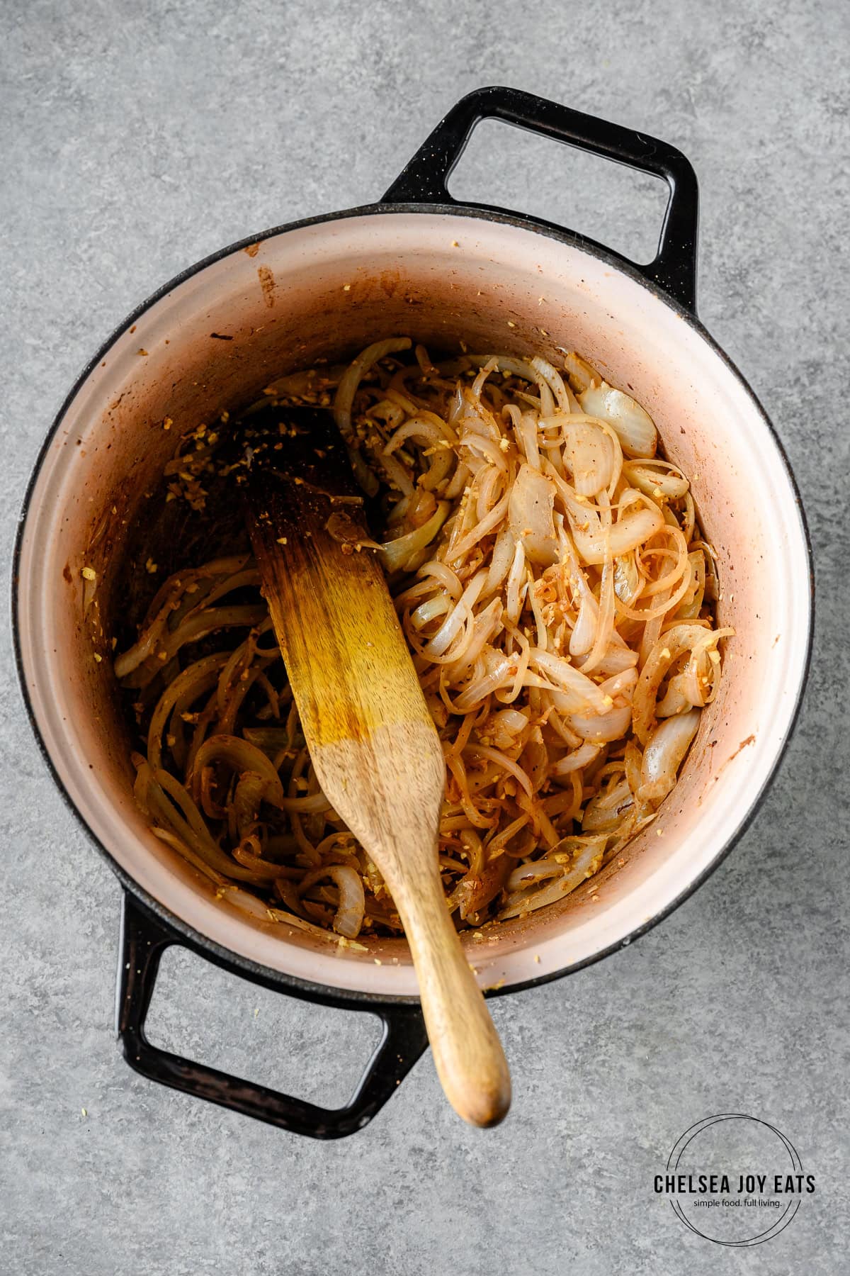 Onions and garlic sautéed in a Dutch oven and stirred with a wooden spatula.
